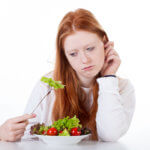 Girl with fork in salad